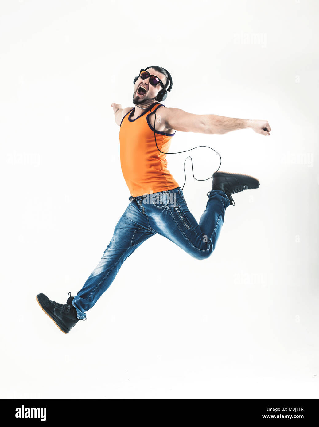 emotional and charming guy - rapper in headphones takes the dance Stock Photo
