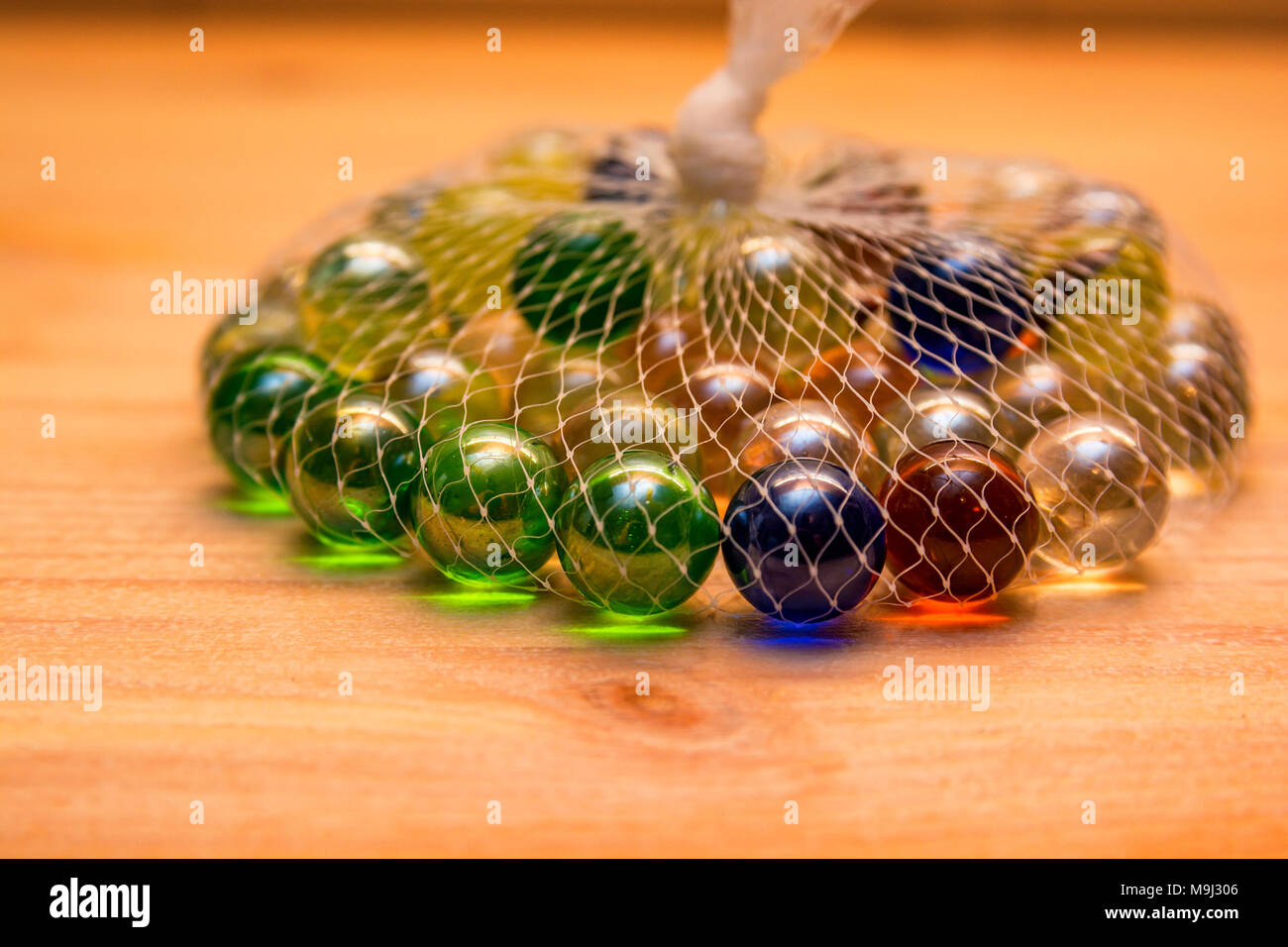 Colorful glass marbles in net Stock Photo Alamy