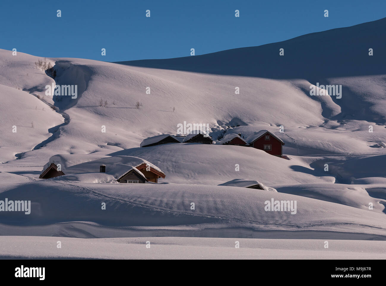 Pristine mountain winterscape with snowdrifts and buried chalets showing mountain pastures at wintertime Stock Photo