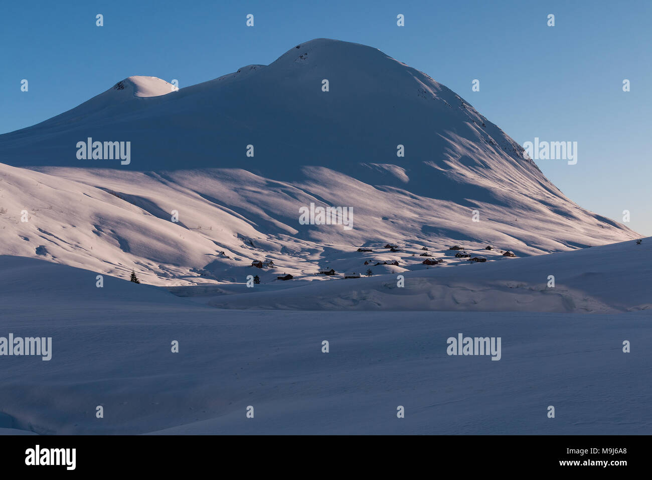 Pristine mountain winterscape with snowdrifts and buried chalets showing mountain pastures at wintertime Stock Photo