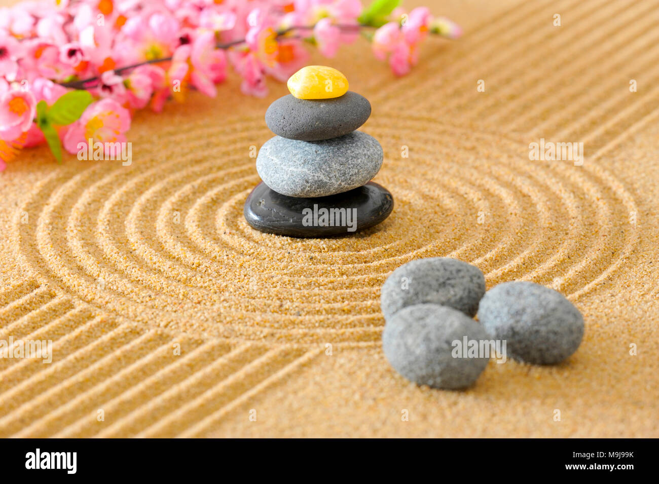 Japanese Zen garden with stacked stones in textured sand Stock Photo