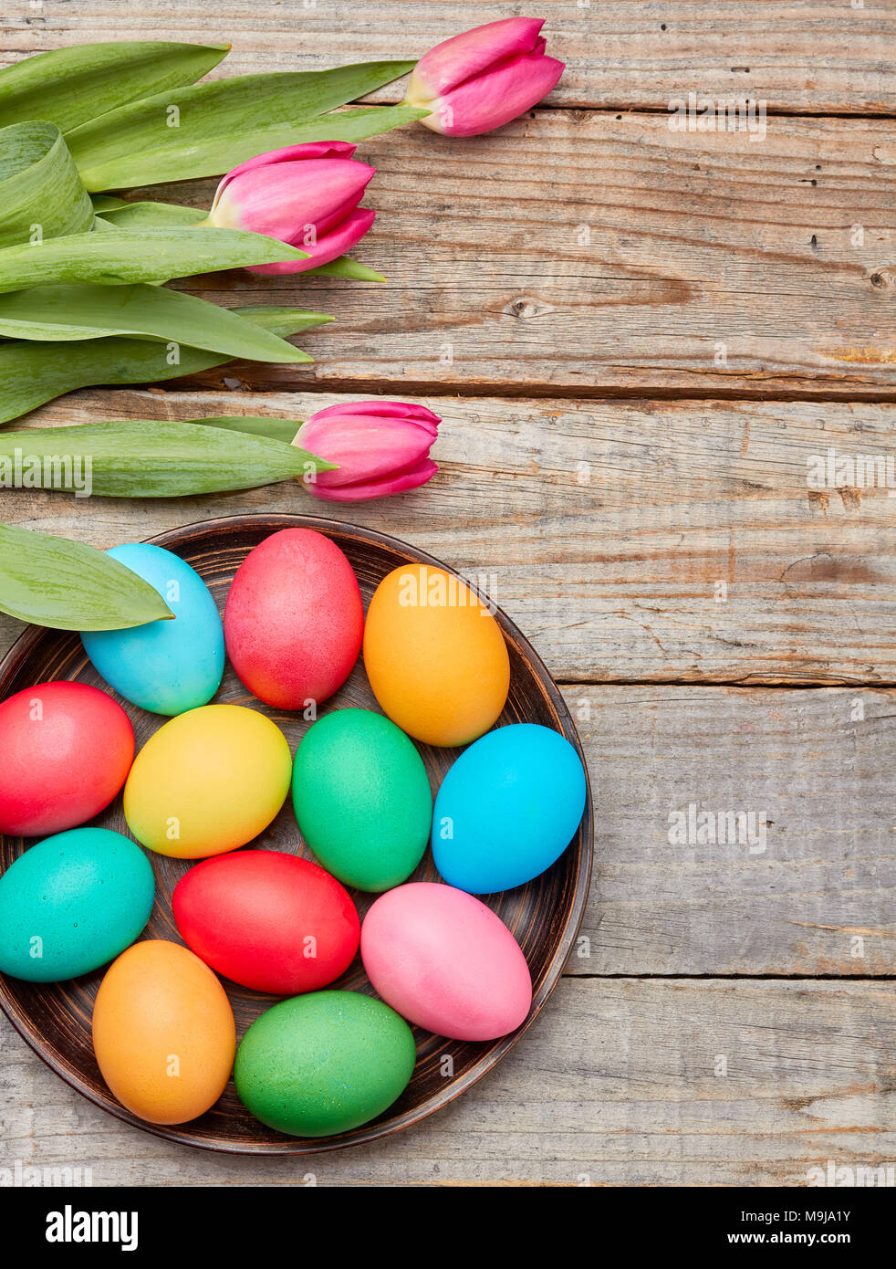 Colorful easter eggs and tulips on wooden background Stock Photo - Alamy
