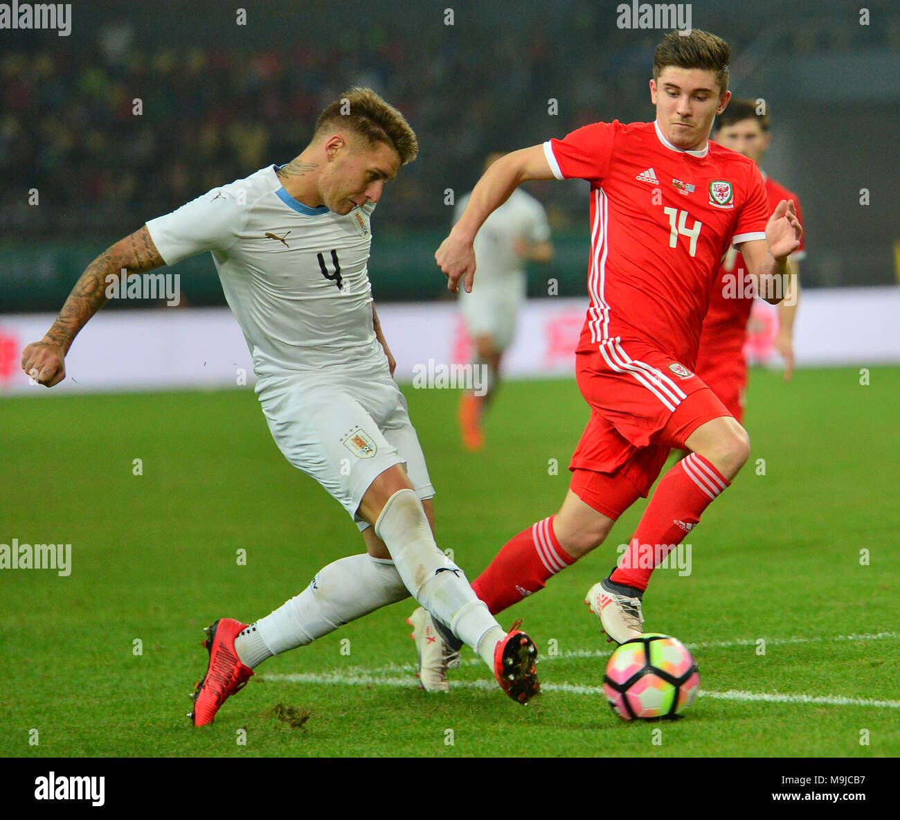 Nanning, China's Guangxi Zhuang Autonomous Region. 26th Mar, 2018. Declan John (R) of Wales vies with Guillermo Varela of Uruguay during the final match between Wales and Uruguay at the 2018 China Cup International Football Championship in Nanning, capital of south China's Guangxi Zhuang Autonomous Region, March 26, 2018. Uruguay won the final by 1-0 against Wales and claimed the title of the event. Credit: Li Xuanli/Xinhua/Alamy Live News Stock Photo