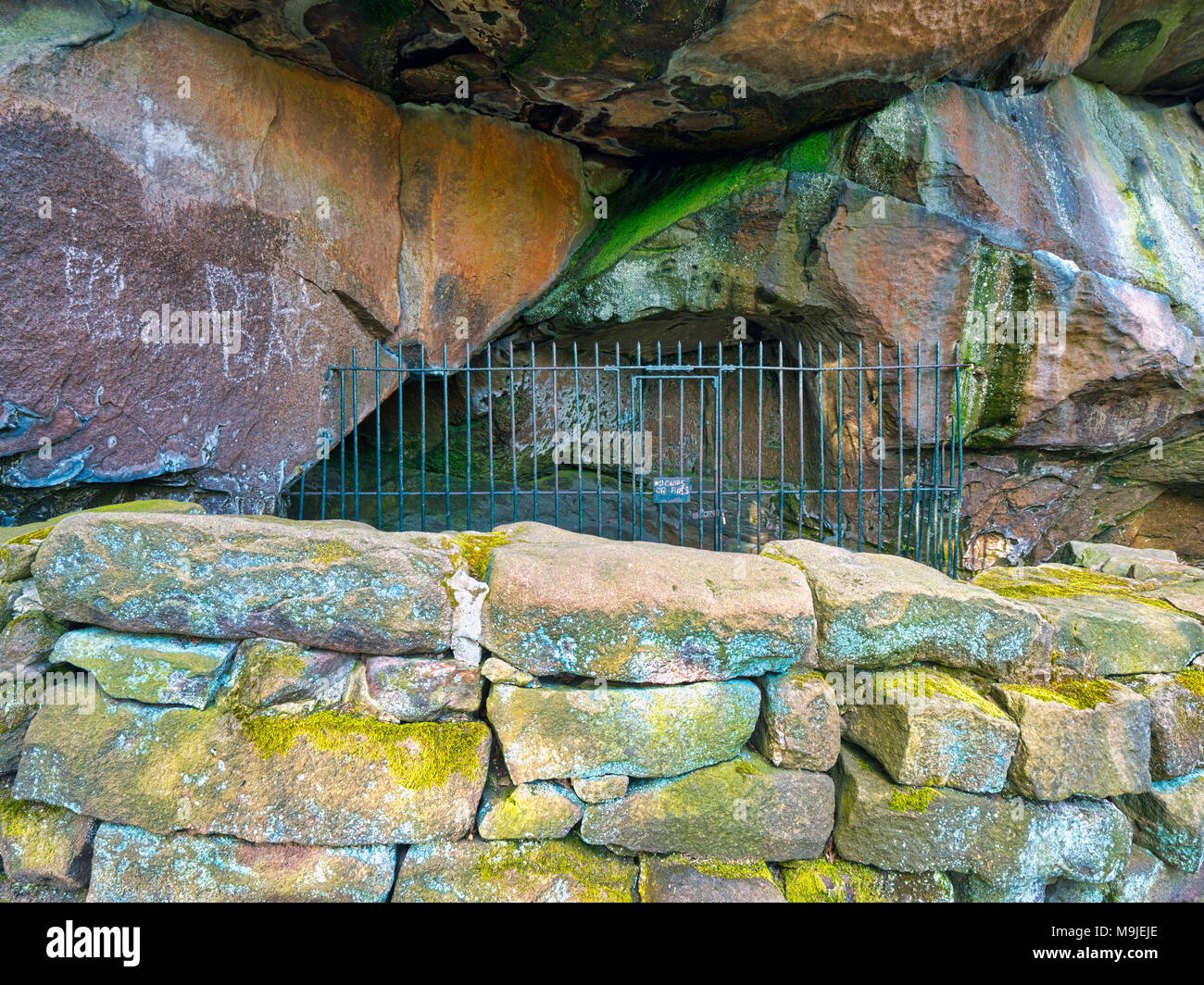 Cratcliffe Rocks, Derbyshire, UK. 26th Mar, 2018. New graffiti scratched into the rocks on the 14th century Hermit's Cave at the base of Cratcliffe Rocks, near the village of Elton, Derbyshire, within a four feet high stone carved Jesus Christ crucifixion on the wall, a niche for a lamp or candle, close to travellers on the Old Portway track Credit: Doug Blane/Alamy Live News Stock Photo