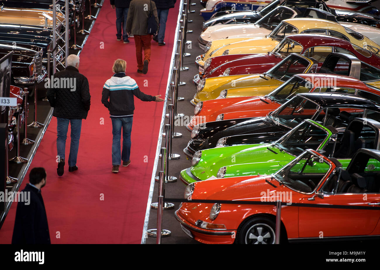 22 March 2018, Germany, Stuttgart: Visitors walking by old Porsche 911s during the Retro Classics classic car fair. Classic cars were on display in Messe Stuttgart between 22 and 25 March 2018. Photo: Marijan Murat/dpa Stock Photo