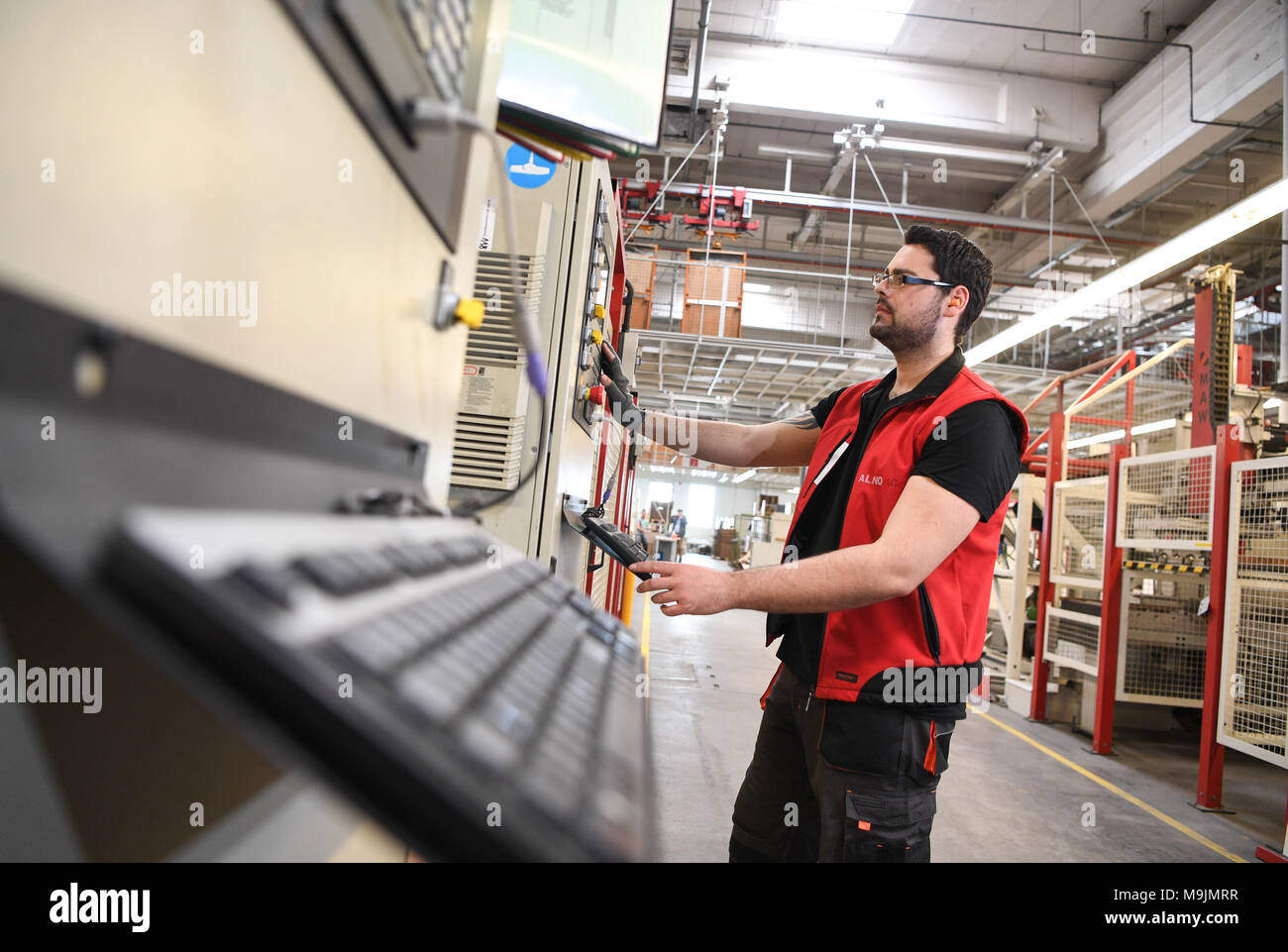 27 March 2018, Germany, Pfullendorf: An employee of kitchen manufacturer Neue Alno GmbH operating a machine that cuts plates for kitchens. The kitchen manufacturer has kicked off mass production after its acquisition by British investor Riverrock. Photo: Felix Kästle/dpa Stock Photo