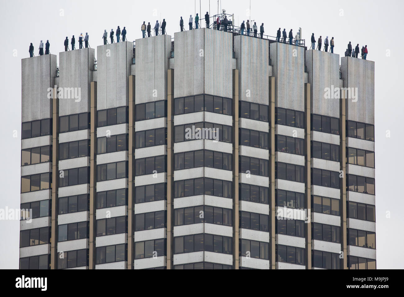 London, UK. 27th March, 2018. 84 life-sized sculptures by Mark Jenkins have been positioned on the top of the ITV Television Centre building as part of Project 84 by the charity CALM (Campaign Against Living Miserably) to represent the 84 men who take their own lives in the UK every week and so to raise awareness of male suicide. Male suicide is the single biggest killer of men under the age of 45 in the UK. Credit: Mark Kerrison/Alamy Live News Stock Photo
