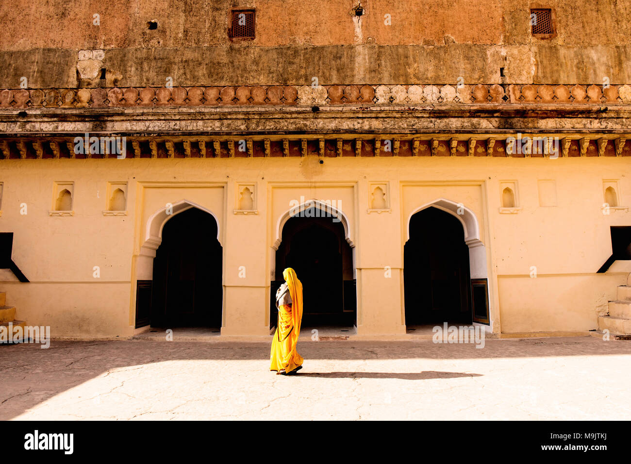 A woman walking past archways in the Amer Fort Stock Photo - Alamy