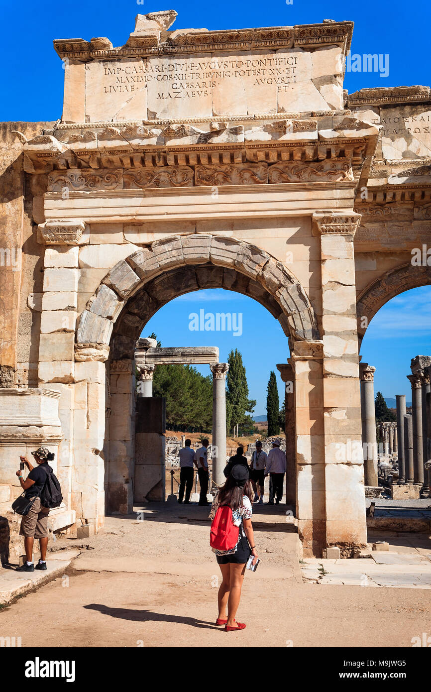 Tourist with a guide book admires the Gate of Augustus in Ephesus. EPHESUS, TURKEY - SEPTEMBER 30, 2014 Stock Photo