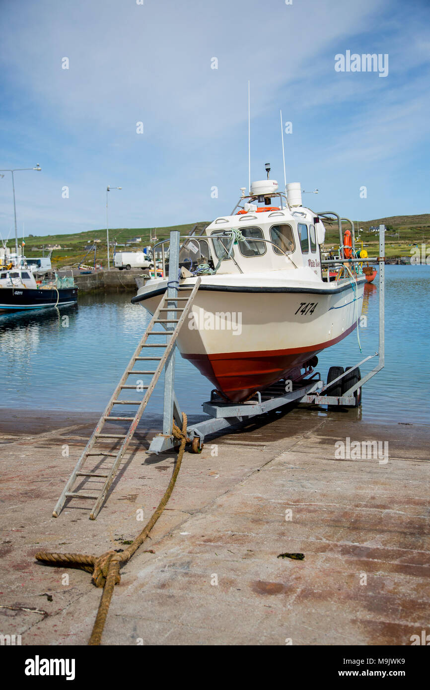 Fishing boat with ladder access on quayside at Portmagee, County Kerry, Ireland Stock Photo