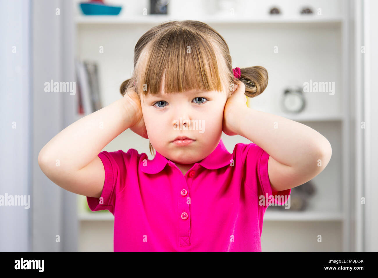Cute little girl covering ears with hands Horizontal Stock Photo