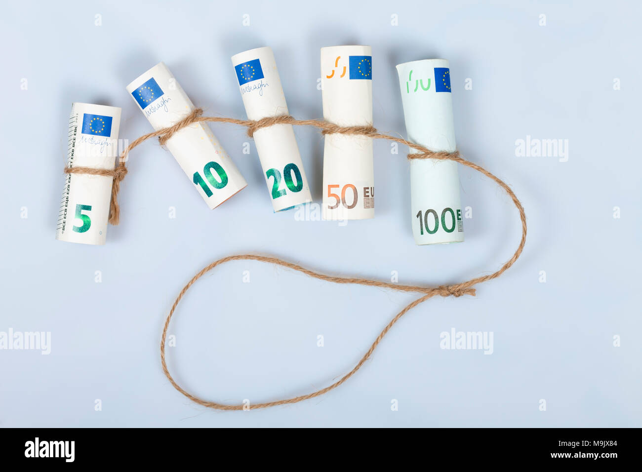 The most used euro bills for Europeans tied with a rope and isolated on white background. Stock Photo