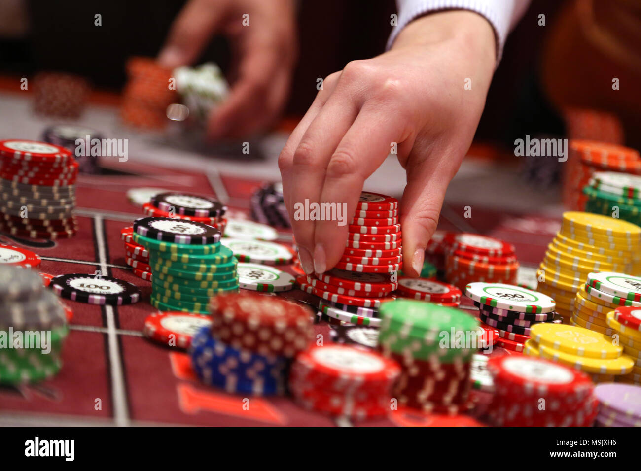Player placing chips on a gambling table in casino Stock Photo