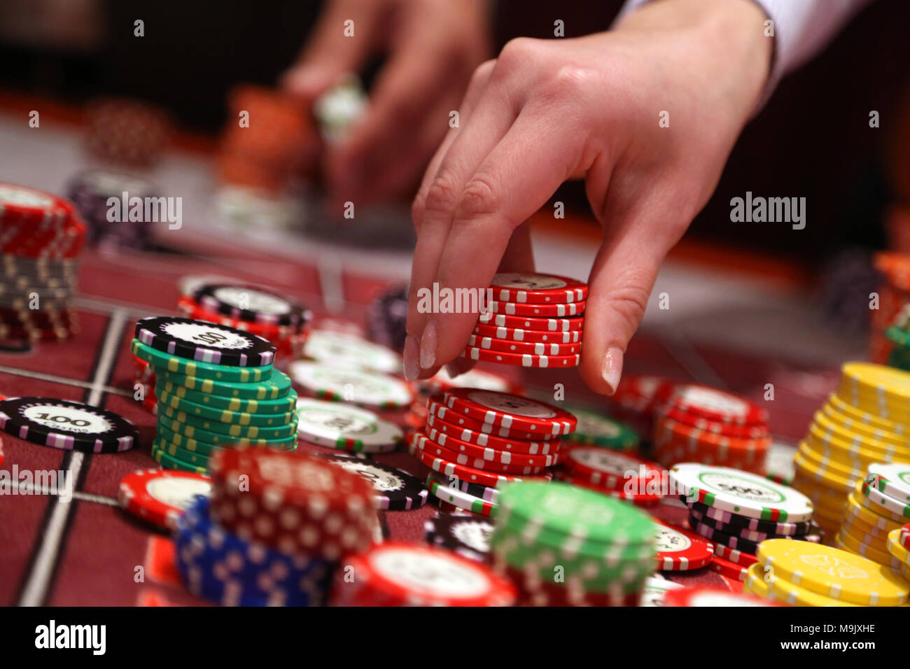 Player placing chips on a gambling table in casino Stock Photo