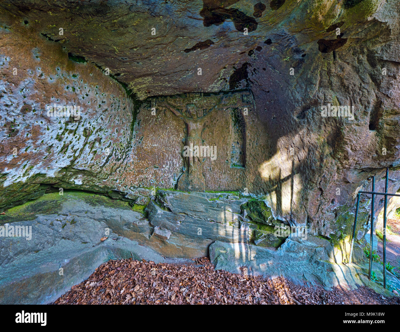 14th century Hermit's Cave at the base of Cratcliffe Rocks, near the village of Elton, Derbyshire, within a four feet high stone carved Jesus Christ Stock Photo