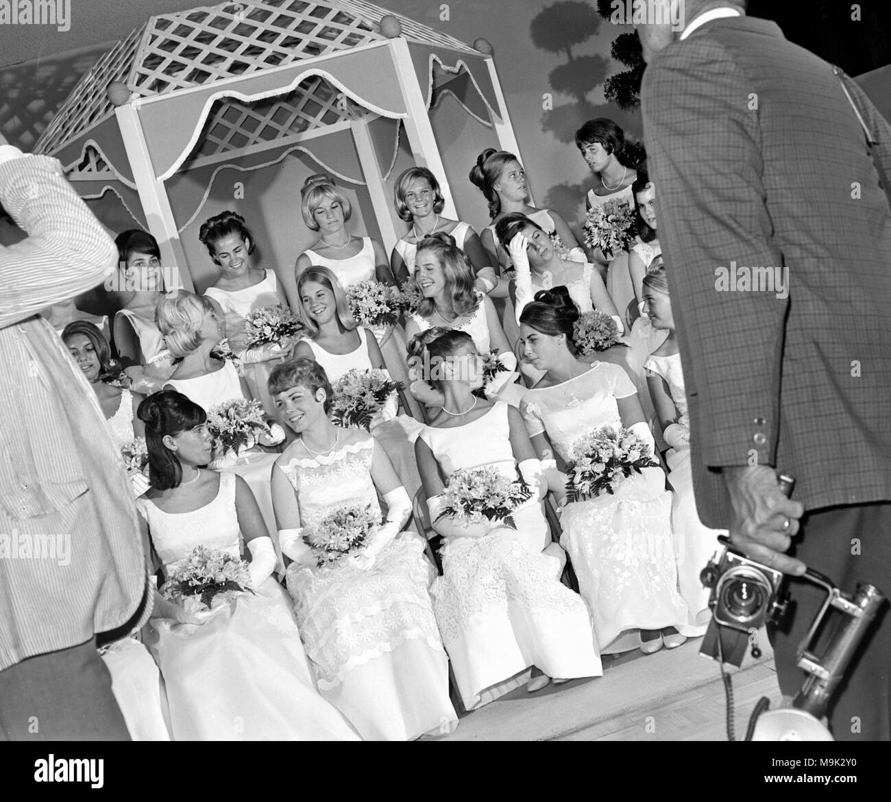 California debutantes relax while two photographers prepare to them for a photo shoot, ca. 1965. Stock Photo