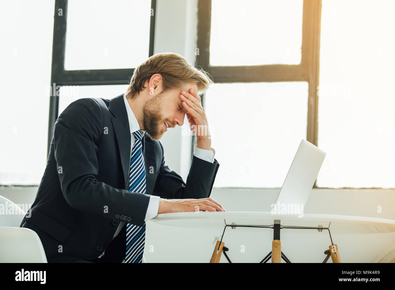 Phone, thinking and man by office window for career inspiration, job search  or online networking. Contemplating asian person or young entrepreneur  cellphone, smartphone or mobile app in workplace Stock Photo