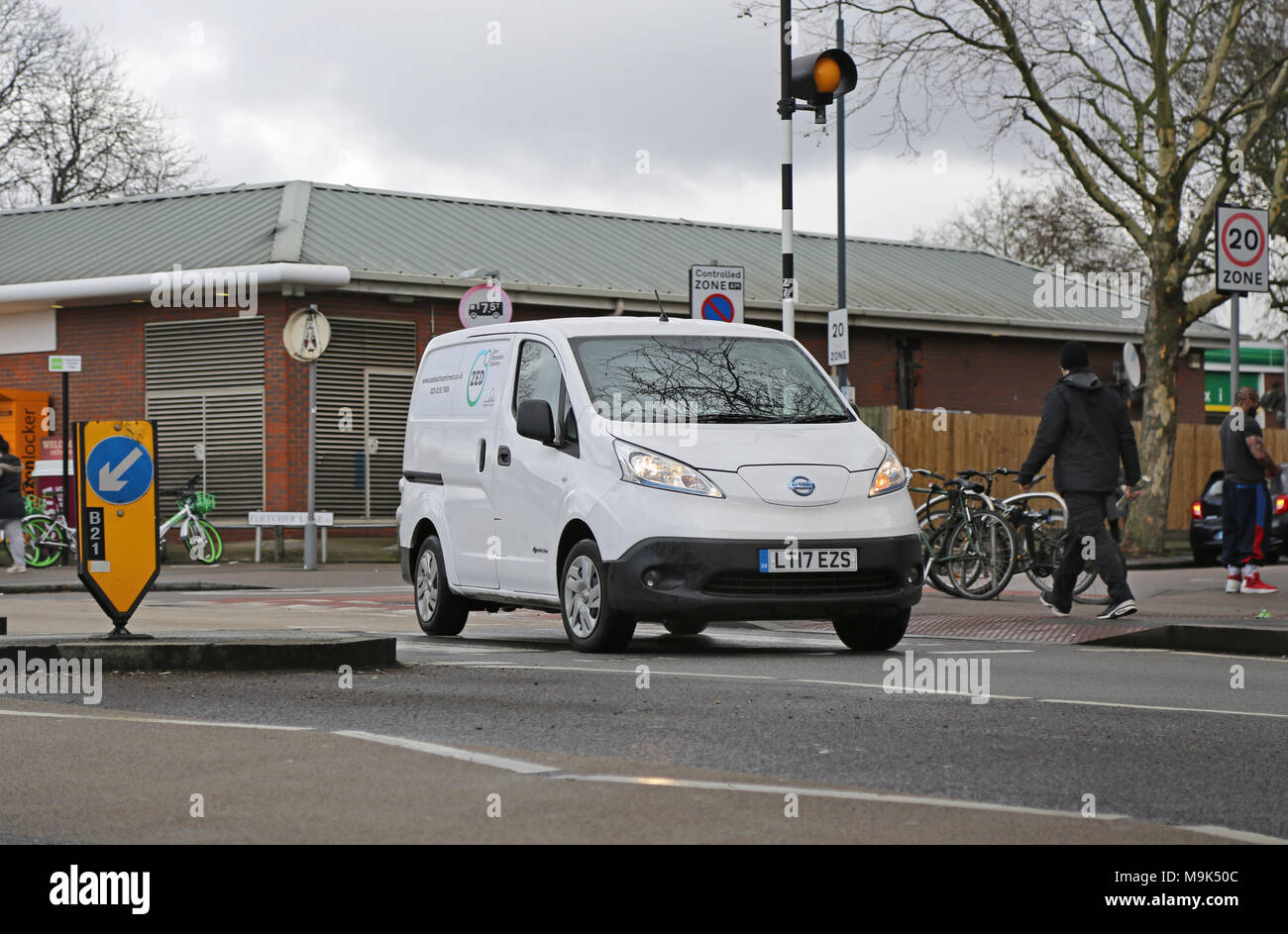 A white Nissan e-NV200 electric van makes deliveries in North London, UK. Branded: Zero Emissions Deliveries' Stock Photo