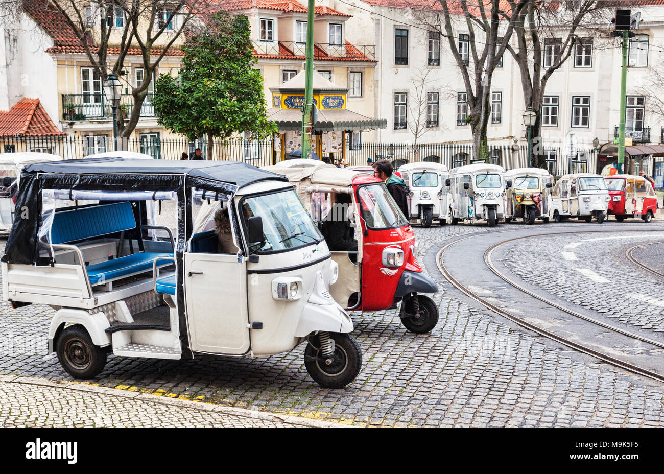1 March 2018: Lisbon, Portugal - Covered tuk tuks ready for hire outside Lisbon Cathedral. Stock Photo