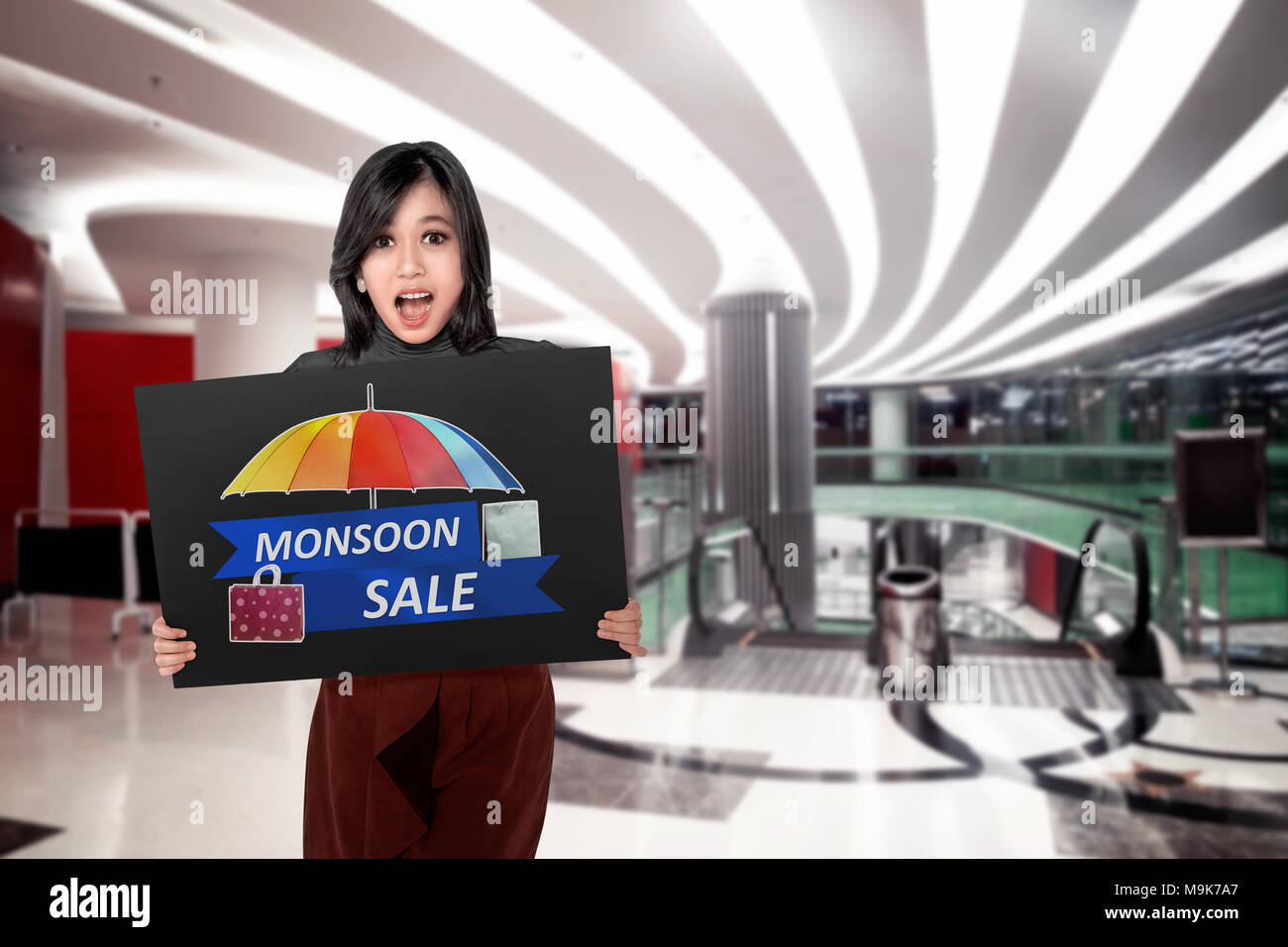 Happy asian woman holding board with Monsoon sale sign. Monsoon sale concept Stock Photo