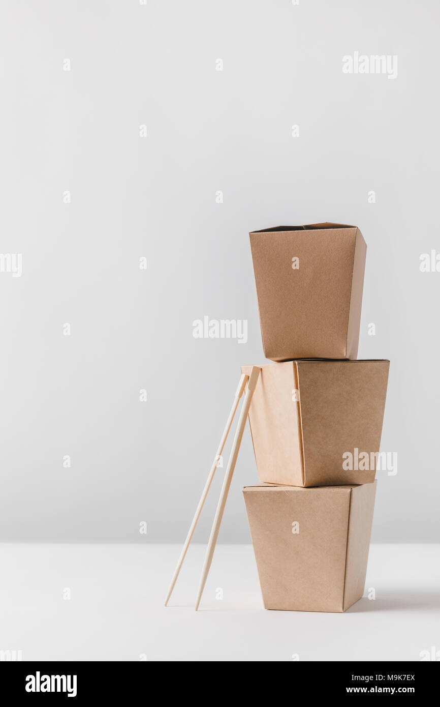 three food containers with chopsticks on table Stock Photo