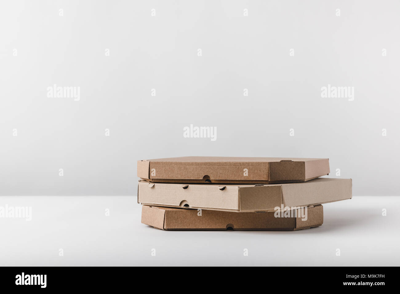 three pizza boxes on white tabletop Stock Photo