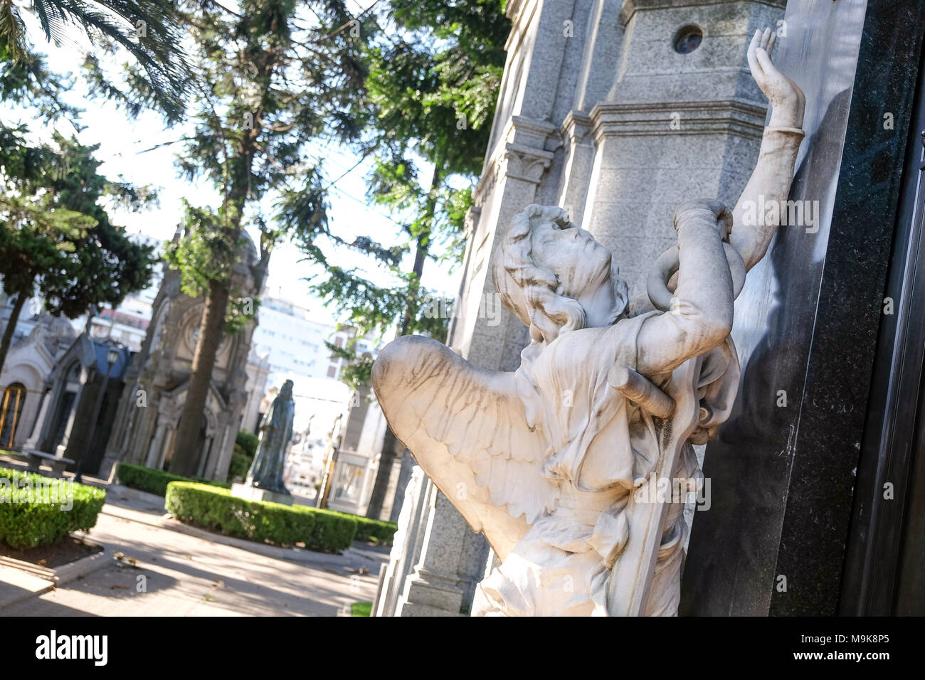 Angel sculpture reaching for a tomb at Recoleta Cemetery in Buenos Aires, Argentina. Stock Photo
