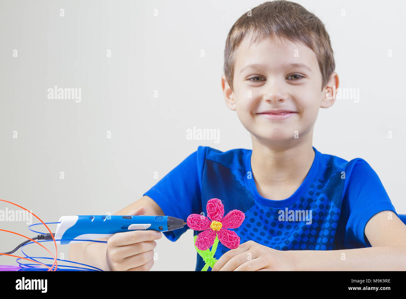 Child creating with blue 3d printing pen Stock Photo - Alamy