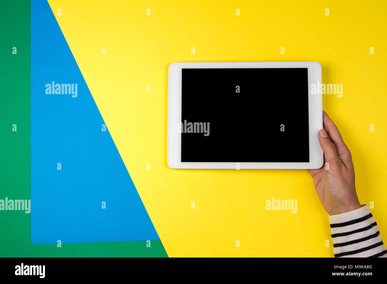 Woman's hands with tablet computer on colorful background Stock Photo