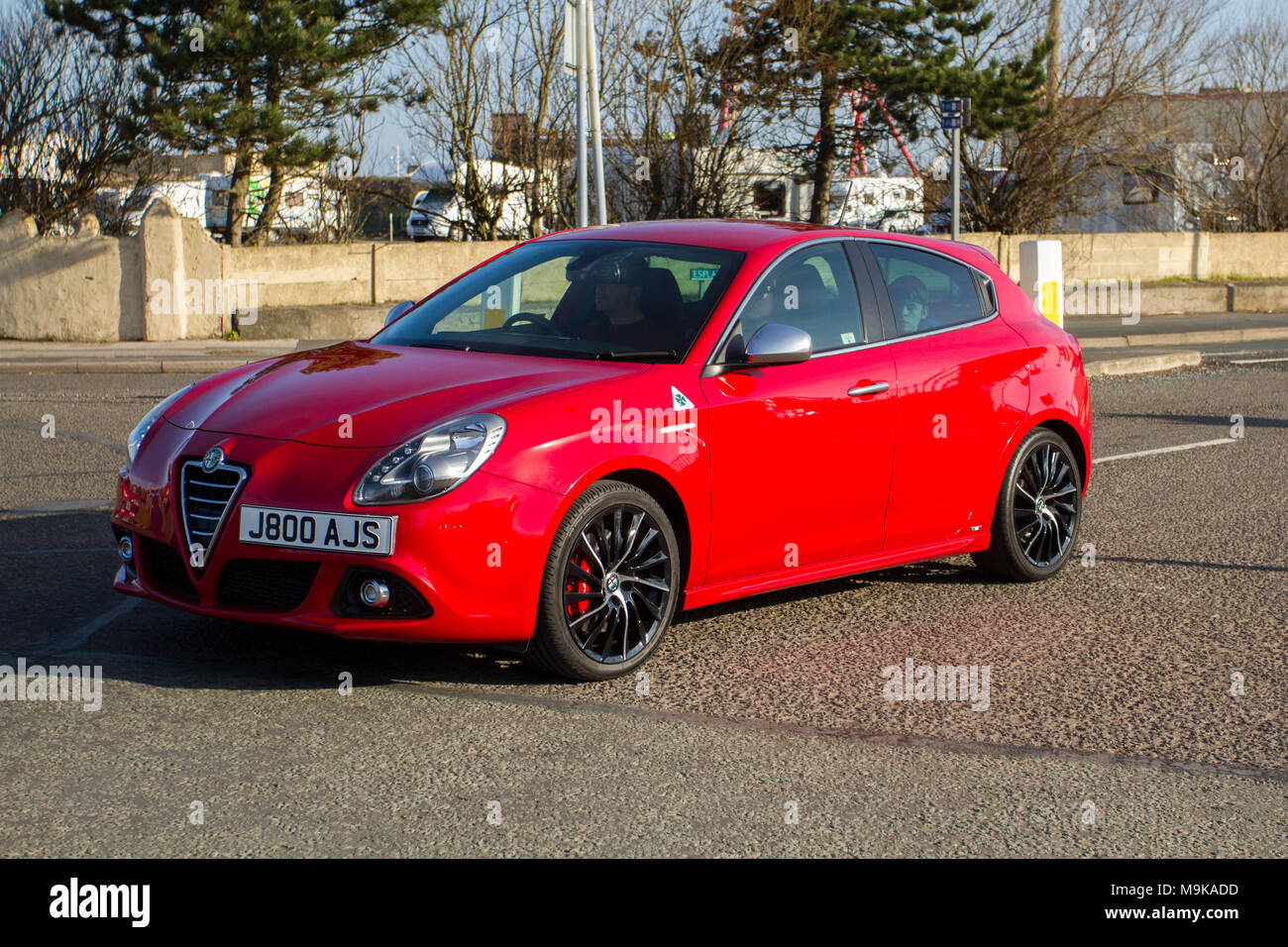 2013 red Alfa Romeo Giulietta Sportiva Multiair hatchback North-West Supercar event as cars and tourists arrive in the coastal resort on a warm spring day. SuperCars are bumper to bumper