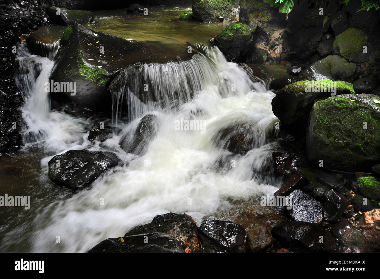 A small cascade flows below Hidden Waterfall at Viento Fresco in Costa Rica Stock Photo