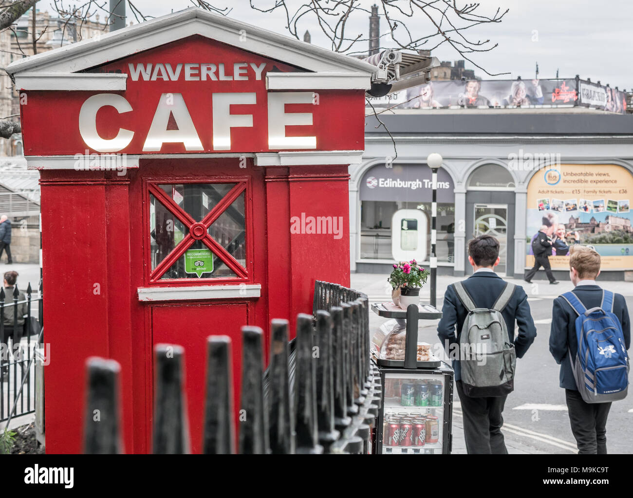 Converted police call box, Waverley Bridge, Edinburgh, Scotland, UK, with schoolboys wearing backpacks walking past Stock Photo