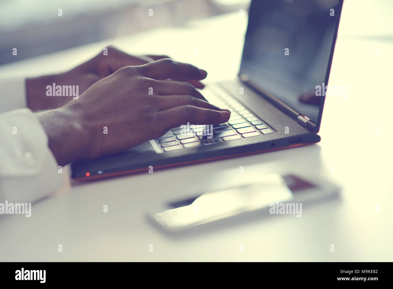 hands with laptop typing in sunlight Stock Photo Alamy