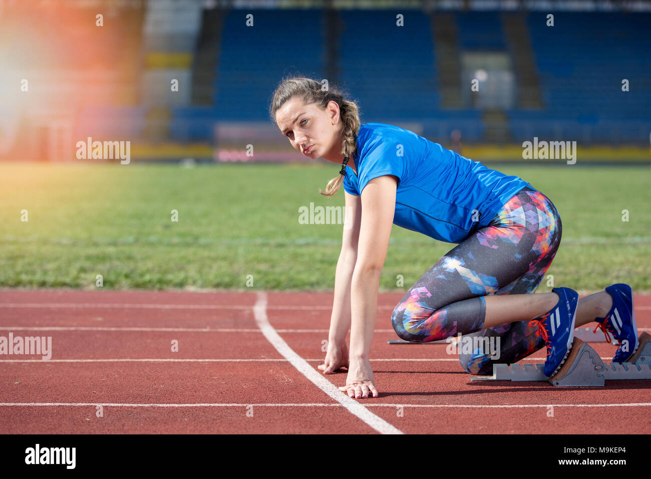 Female athlete running on the racing track on a sunny day Stock Photo ...