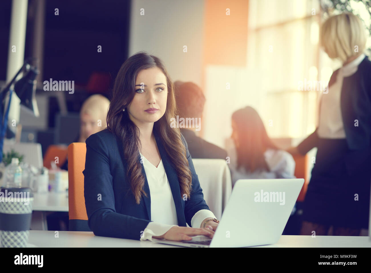Image of woman using laptop while sitting at her desk Stock Photo - Alamy
