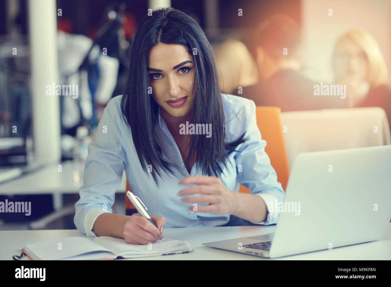 Image of woman using laptop while sitting at her desk Stock Photo - Alamy