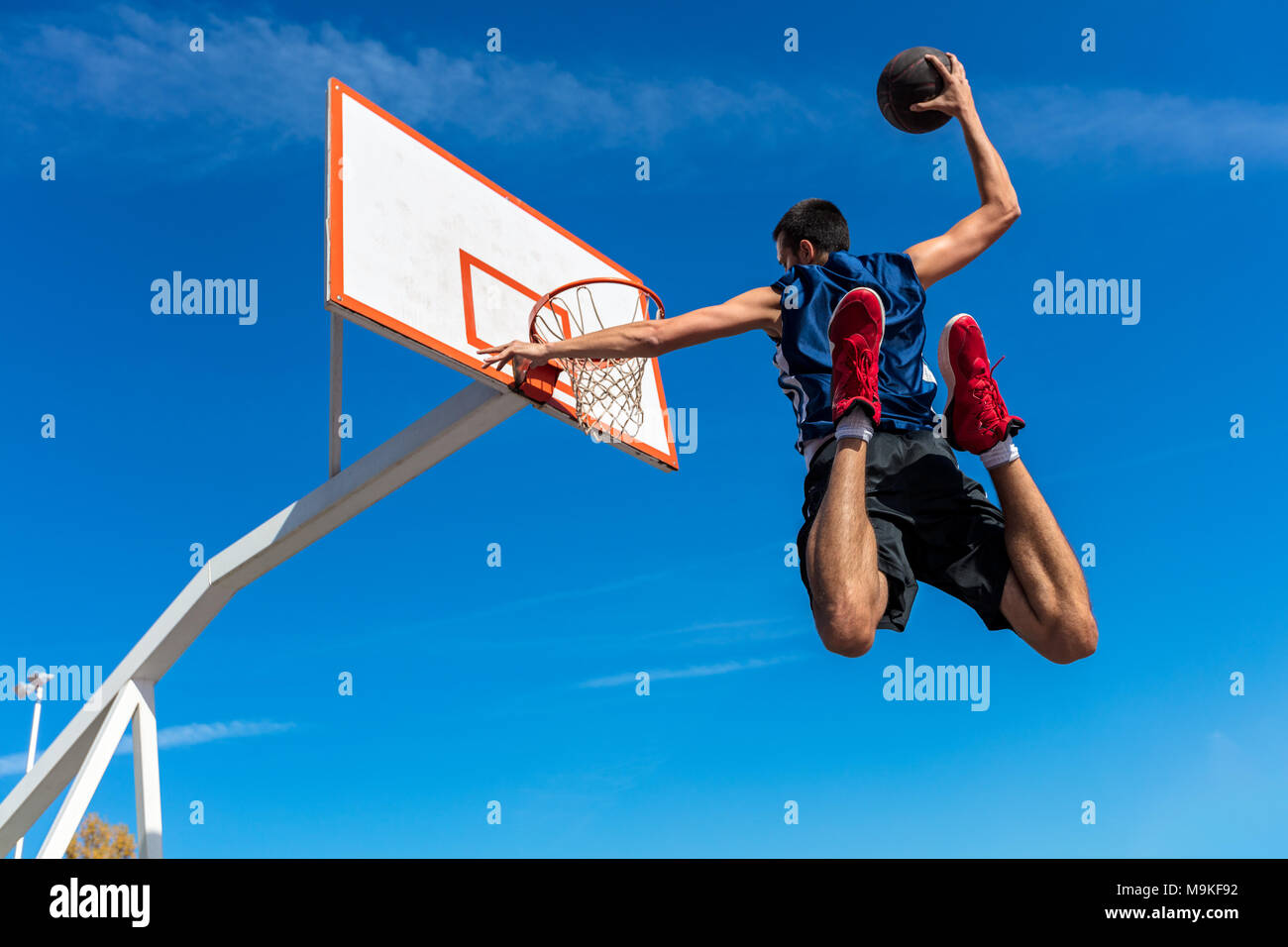 Young Basketball street player making slam dunk Stock Photo Alamy
