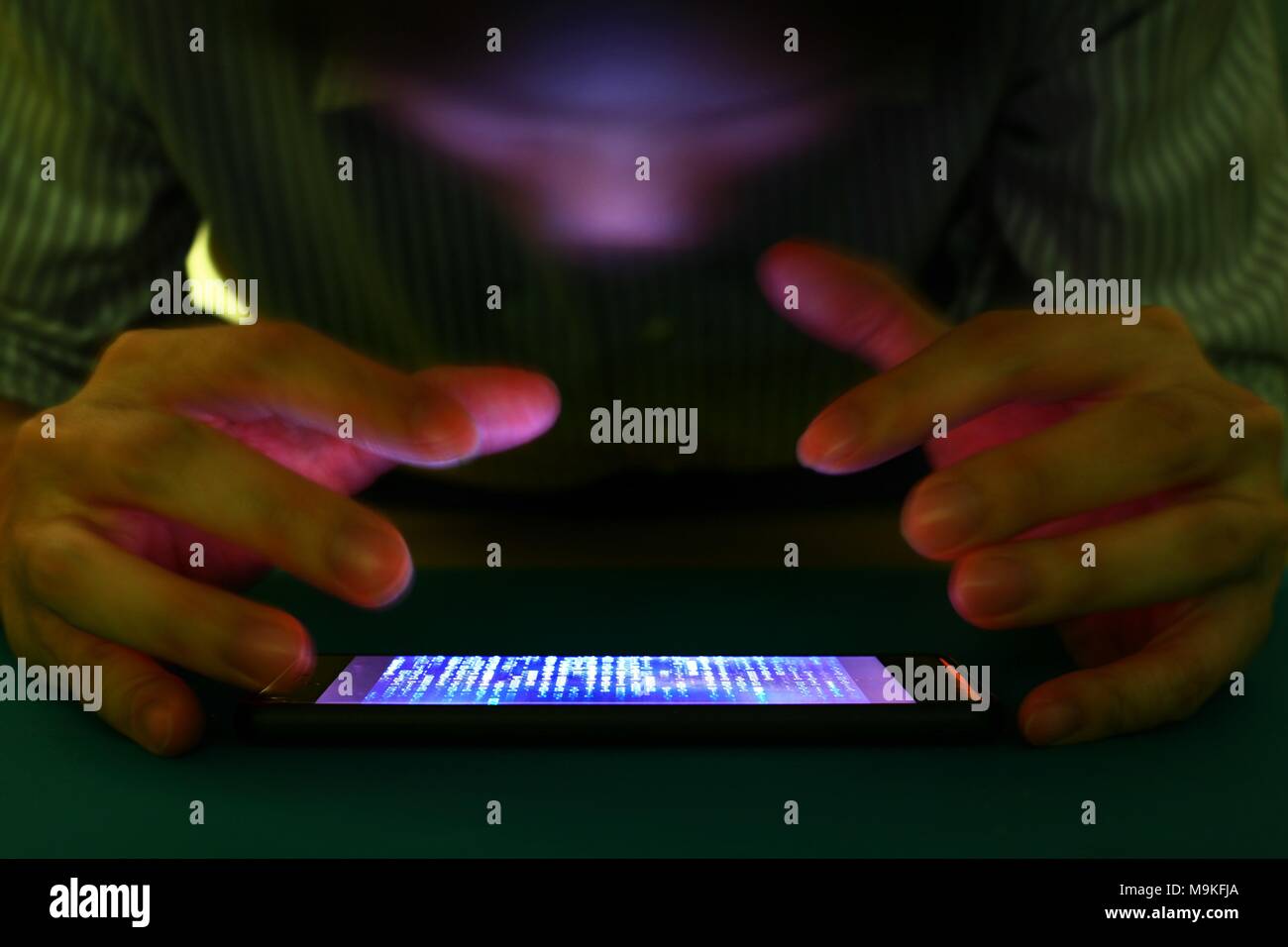 Is Cell Phone Using Binary Code smartphone with code binary on screen. man trying to get pass lock ...