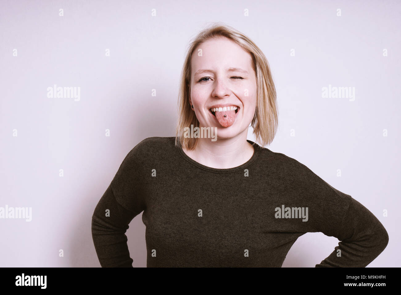 silly young woman sticking out tongue and winking Stock Photo