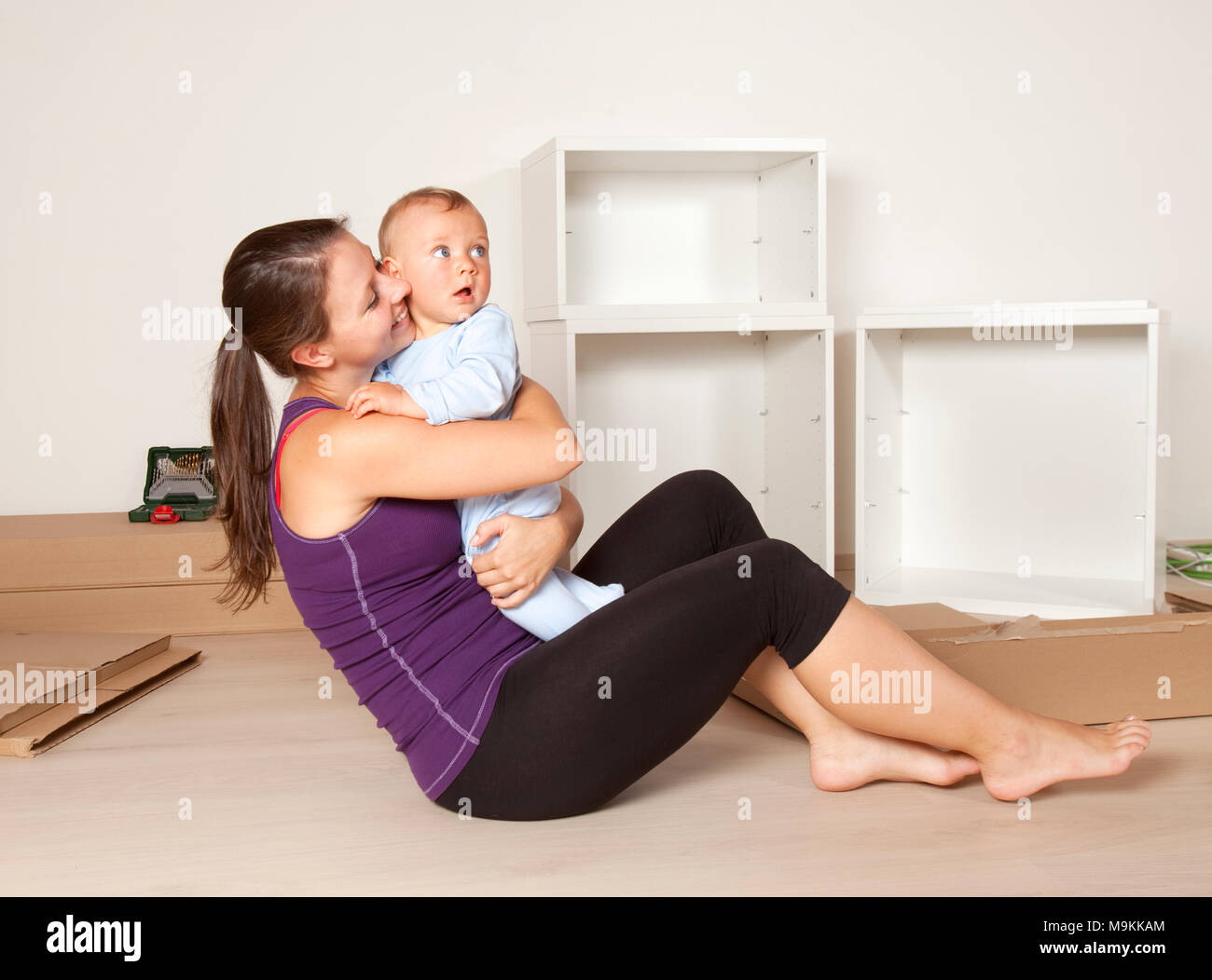 Young Mother with a Baby Moving to New Flat Stock Photo