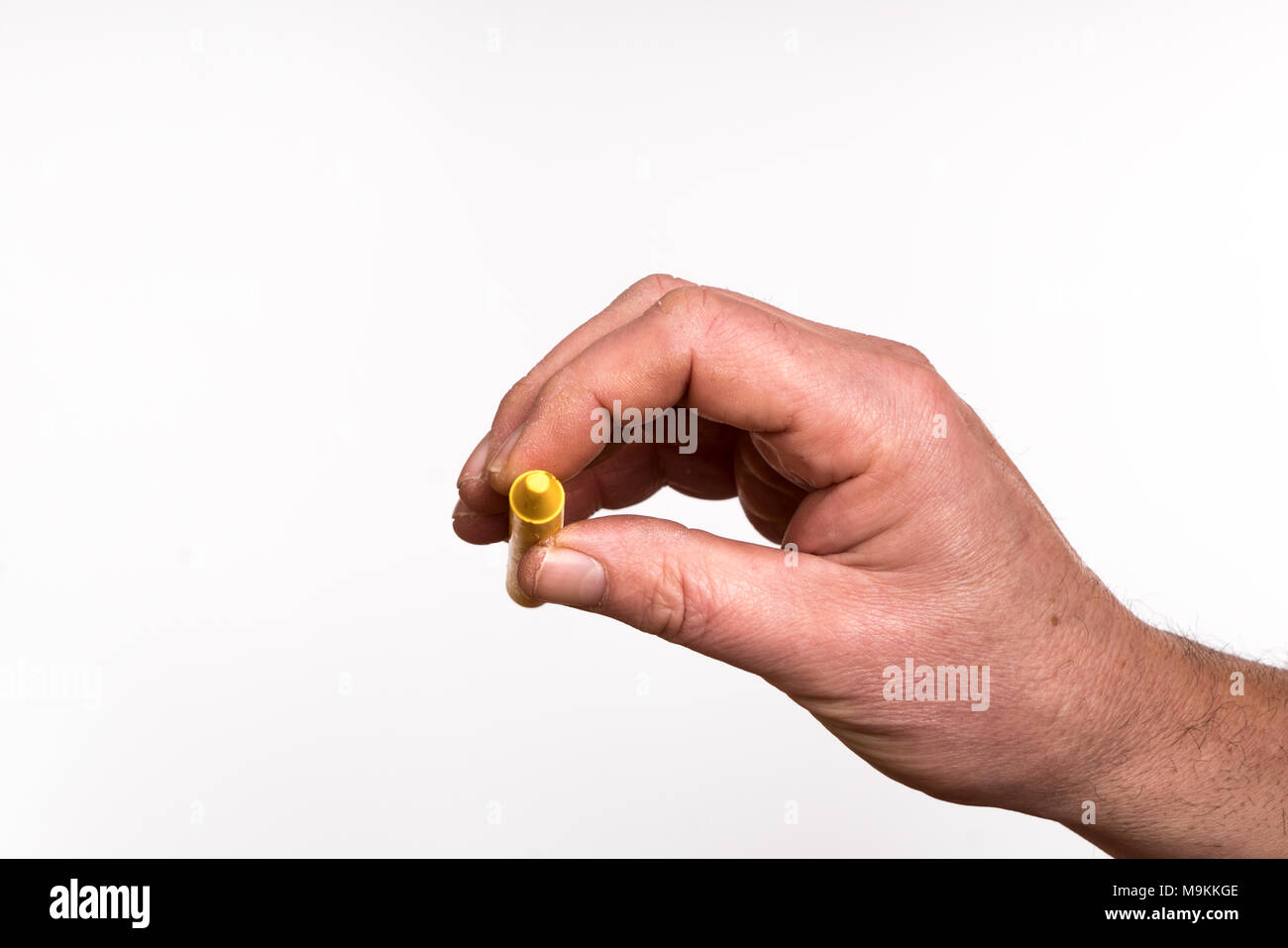 A yellow wax crayon in the hand Stock Photo