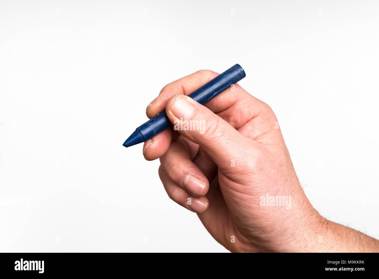 A blue wax crayon in the hand Stock Photo