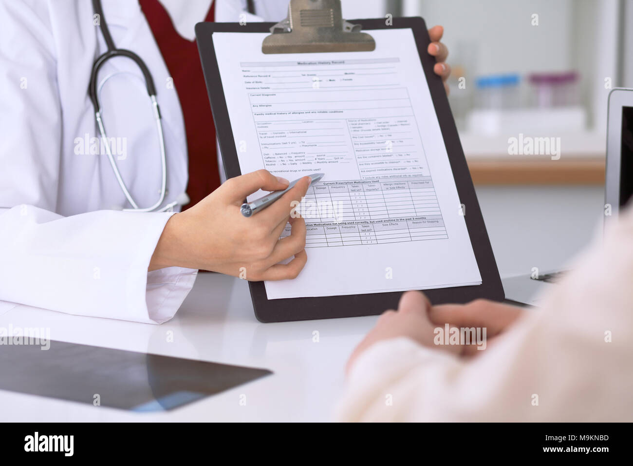 Doctor Application Images Close up of a female doctor pointing into an application form while ...