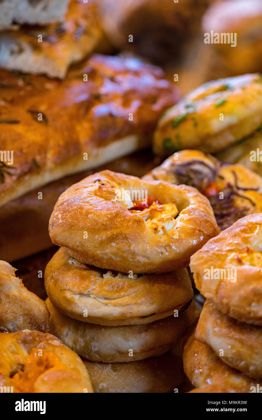 freshly baked bread rolls baguettes and bagels with pastries at borough market in central london on an artisan bakers stall or bakery stalls. foods. Stock Photo
