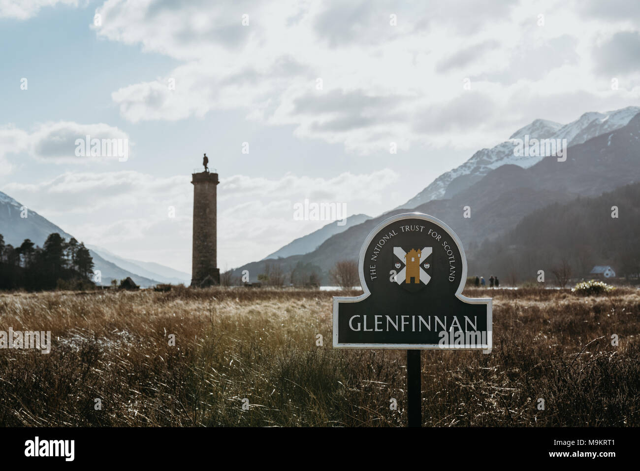 Close up of Glenfinnan sign, Glenfinnan Monument on the background. The monument is cared for by the National Trust for Scotland. Stock Photo