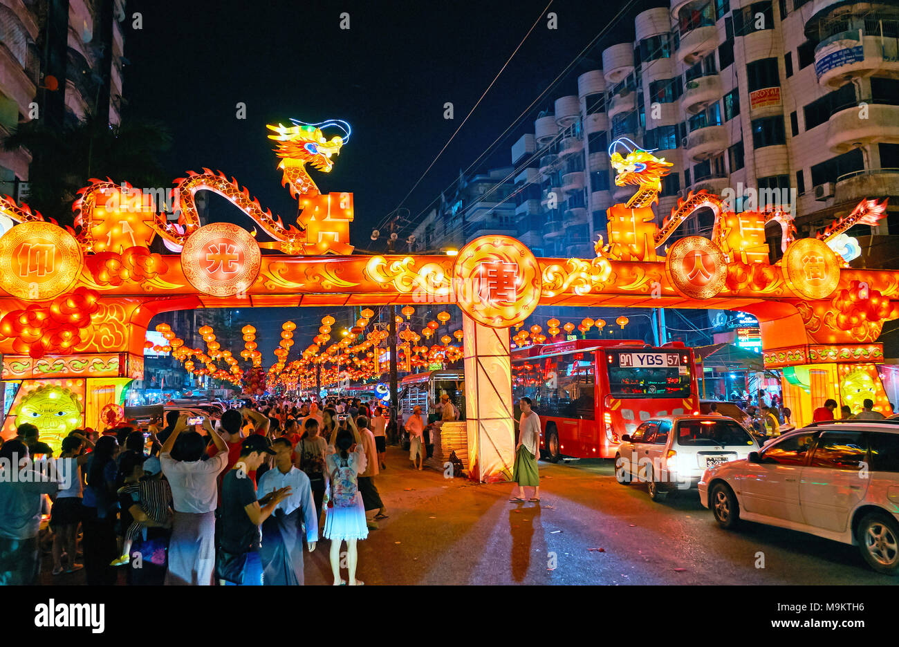 YANGON, MYANMAR - FEBRUARY 14, 2018: The crowd of locals and tourists at the entrance gate to the Spring Festival (Chinese New Year) in Chinatown, dec Stock Photo