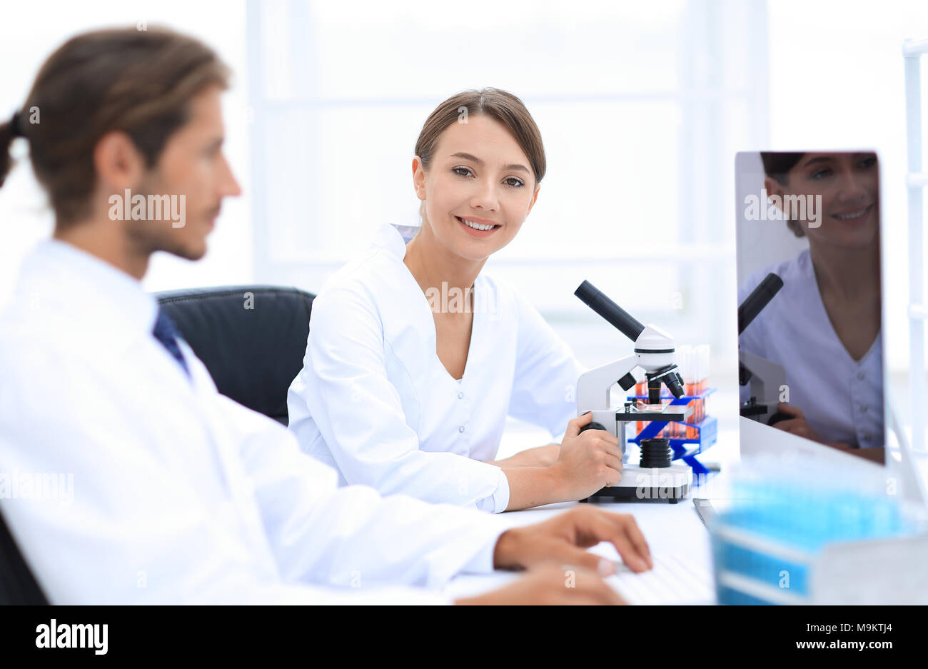 Lab expert working on a test using microscope Stock Photo