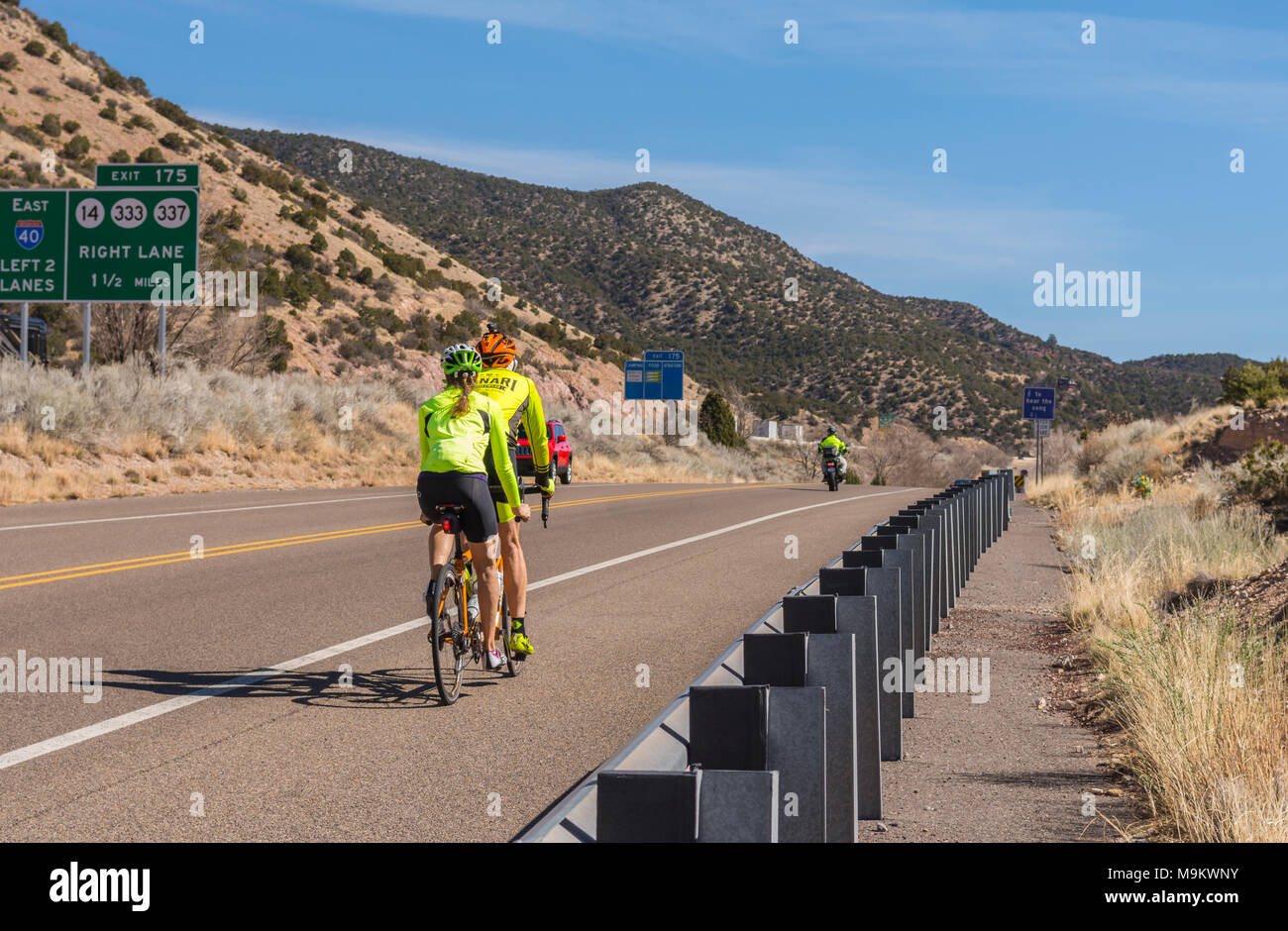 A couple rides a tandem mountain bike on old Route 66 near Tijeras, New Mexico, USA. Stock Photo