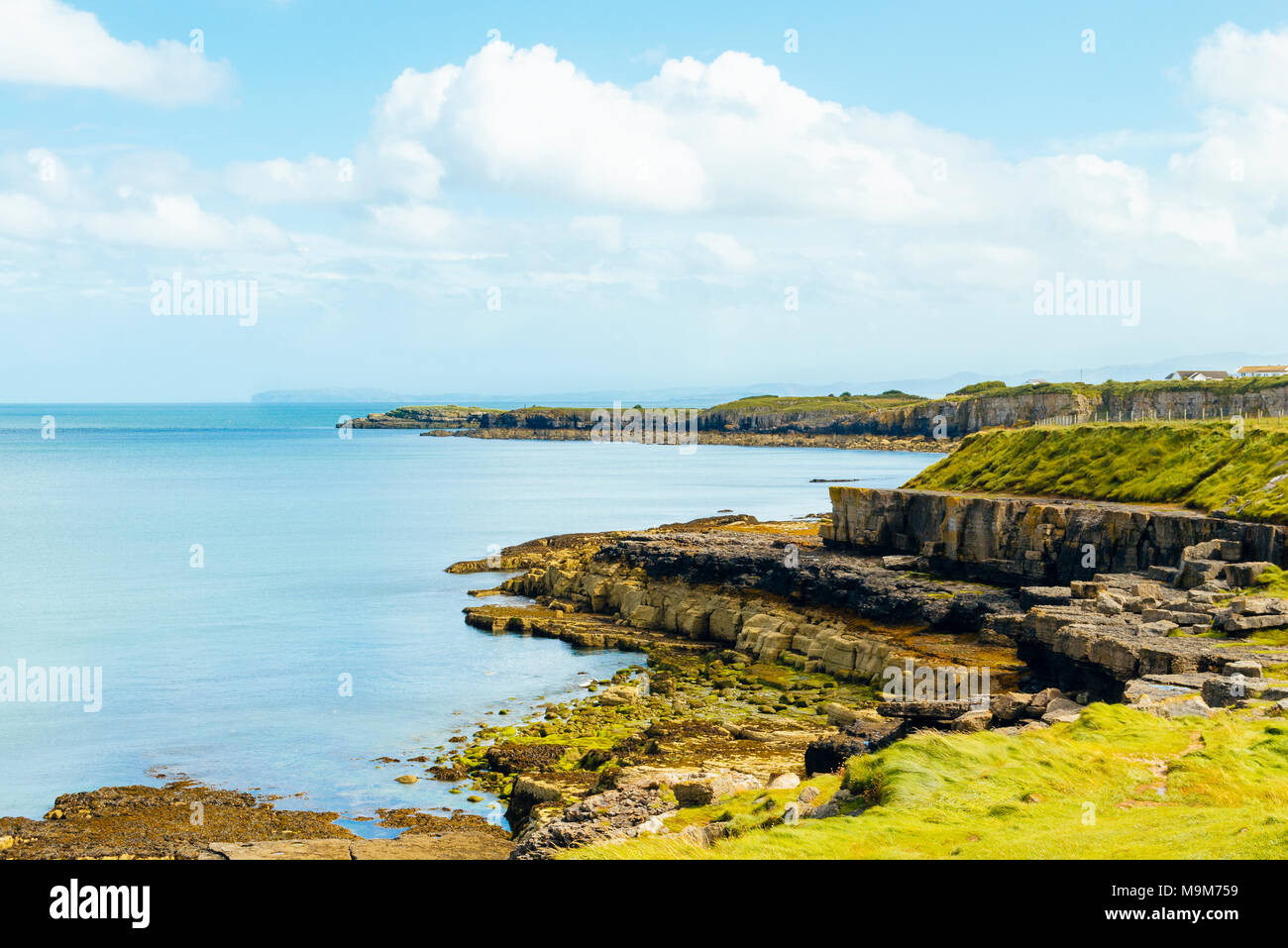 Coastline near Moelfre, Anglesey, Wales. Llandudno's Great Orme appears on the horizon. Stock Photo