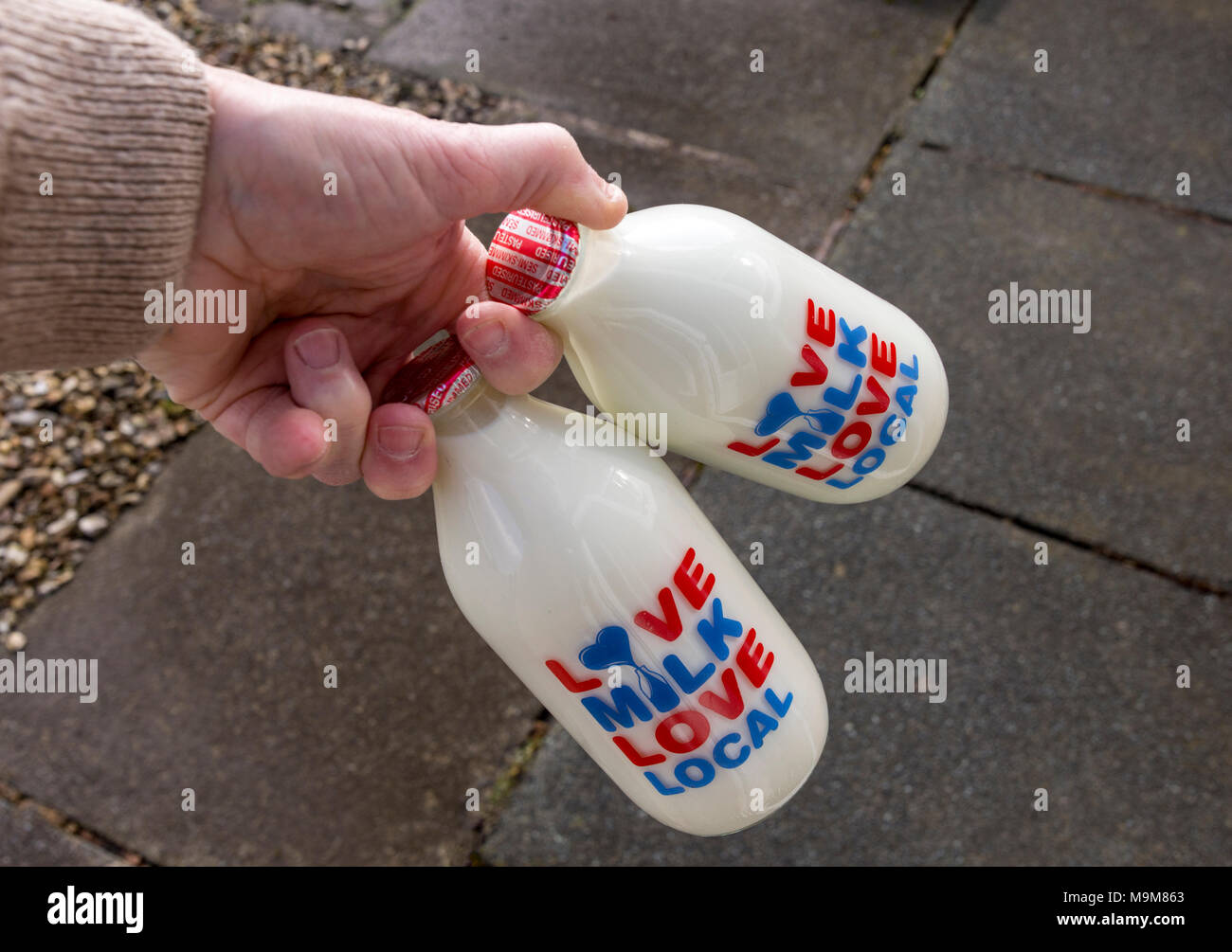Glass milk bottles. Love Milk Love Local Delivery Stock Photo